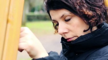 Sonbahar parkta bir salıncak üzerinde depresif kız
