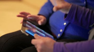 Annesi bir tablet Pc veren ve onu kullanmak için öğretim yetişkin kadın