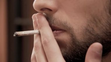 Bir yirmili genç adam açık havada duvara yaslanmış