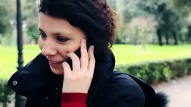 Kadın cep telefonuyla konuşuyor.