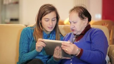 Granddoughter büyükannesi nasıl yeni Tablet Pc kullanılacağını gösteren sahiptir
