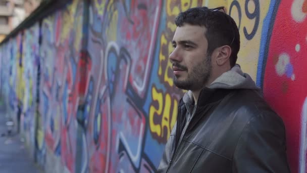 Man leaning against a suburban wall — Stock Video