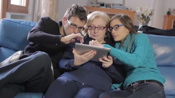 Famille heureuse (mère et deux fils) en utilisant la tablette PC à la maison sur le canapé — Video