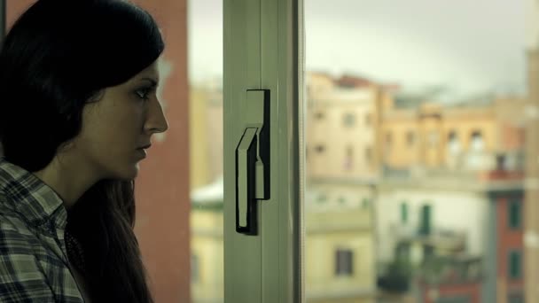 Sad beautiful woman looking out window — Stock Video
