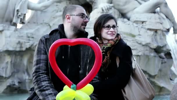 Young outdoor portrait of beautiful couple kissing on Bernini fountain — Stock Video