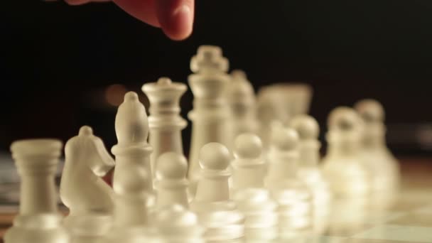 Girl playing with glass chess: move, chessboard, moving pawn, red warm light — Stock Video