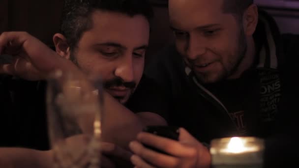 Двоє чоловіків з мобільним телефоном у пабі — стокове відео