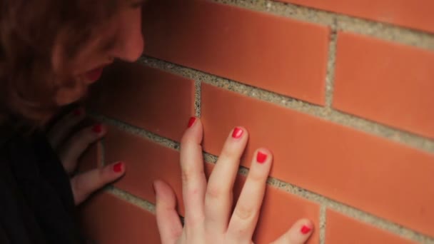 Mujer triste junto a la pared — Vídeo de stock