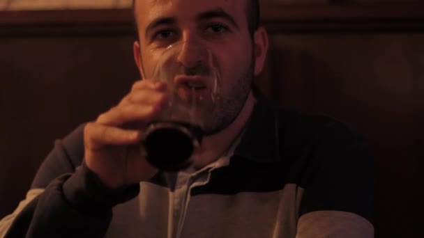 Расслабленный мужчина пьет пинту пива улыбаясь — стоковое видео