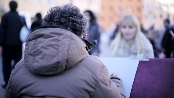 Närbild på Piazza Navona gatukonstnär skisser ett porträtt av ett par — Stockvideo