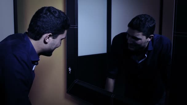 Депресивний чоловік дивиться у дзеркало на своє розлючене відображення — стокове відео