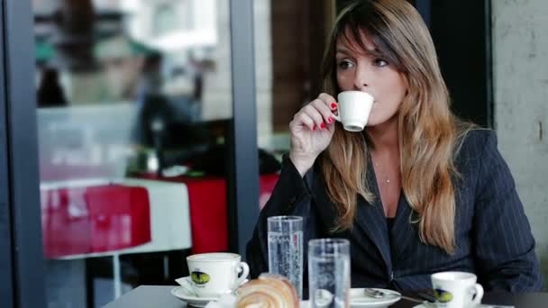 Junge Geschäftsfrau trinkt Kaffee im Café — Stockvideo