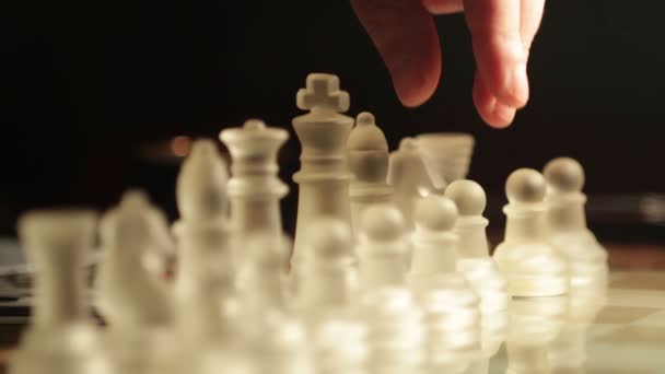 Girl playing with glass chess: move, chessboard, moving pawn, red warm light — Stock Video