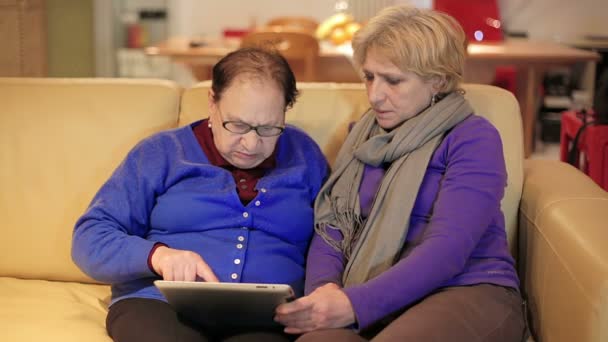 Vrouw leert haar moeder gebruik met tablet pc - senior levensstijl — Stockvideo