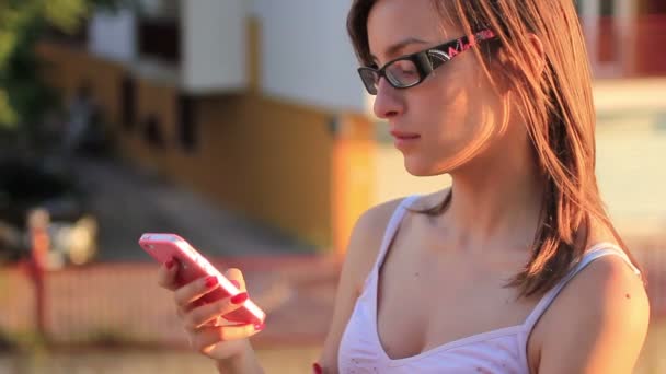 Chica joven usando teléfono inteligente — Vídeo de stock