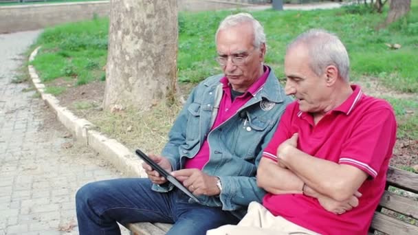 Old man teaching his elderly friends to use a new tablet PC — Stock Video