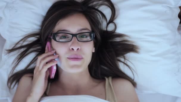 Vrouw met smartphone in bed — Stockvideo
