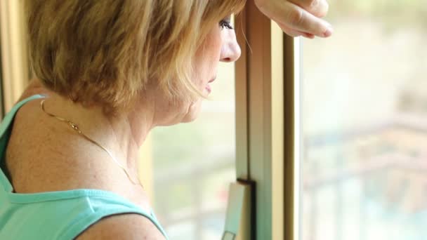 Mujer triste cerca de ventana — Vídeos de Stock