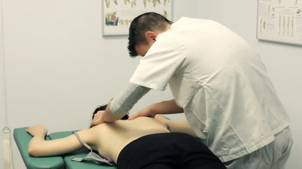 Therapist is massaging young patient on shoulders and neck; massage, back. — Stock video