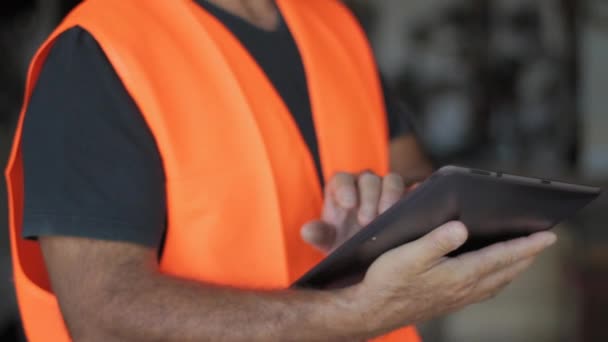 Warehouseman with protective vest and tablet — Stock Video