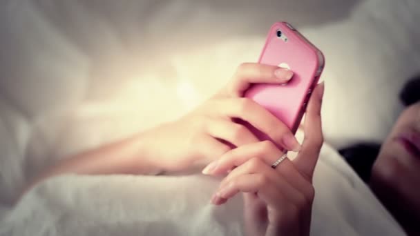 Femme utilisant un smartphone au lit — Video