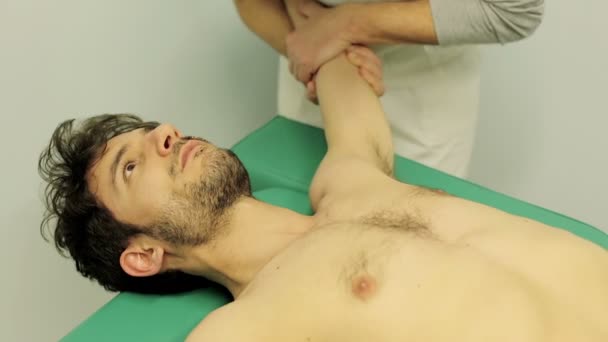 Movements of the shoulder of a young patient: chiropractor, doctor, physical — Stock video