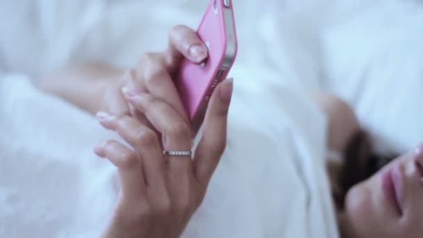 Femme utilisant un smartphone au lit — Video