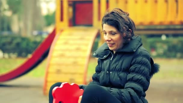 Syndrome de Peter Pan - femme de 35 ans sur une aire de jeux extérieure en automne — Video
