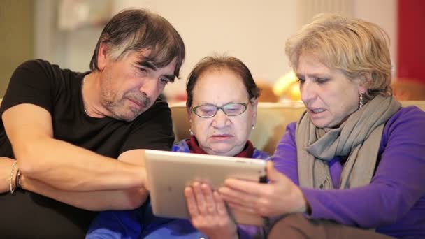 Zoon en dochter geven hun moeder een tablet Pc en het onderwijzen van haar om het te gebruiken — Stockvideo