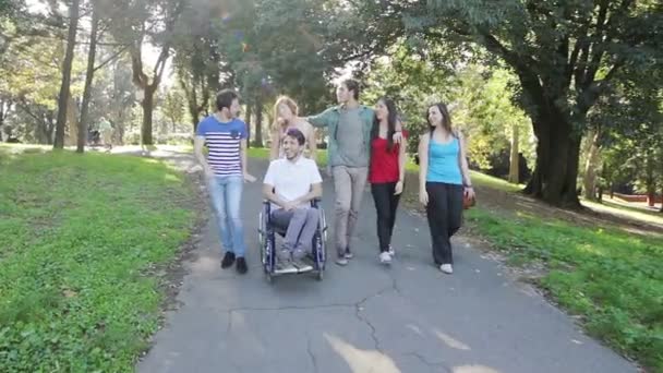 Jovem deficiente se divertindo com amigos no parque — Vídeo de Stock