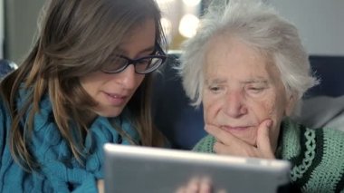 Granddoughter büyükannesi nasıl yeni Tablet Pc kullanılacağını gösteren sahiptir