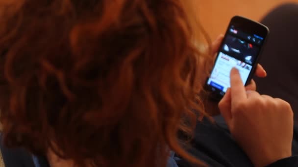 Kvinna med en smartphone för att se video på youtube — Stockvideo