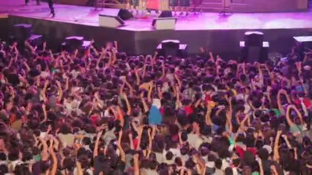 Focus on huge crowd of people dancing and clapping his hands during a concert — Stock Video