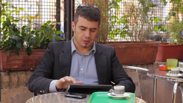 Uomo d'affari che lavora sul computer tablet nel caffè — Video Stock