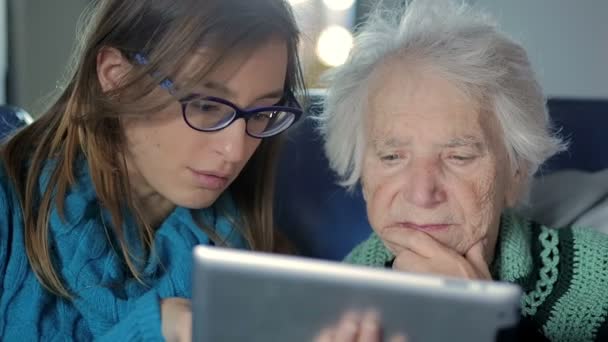 Granddaughter Teaching Grandmother How to Use a Tablet PC — Stock Video