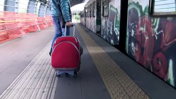 Junger Mann mit Gepäck auf dem Bahnsteig — Stockvideo