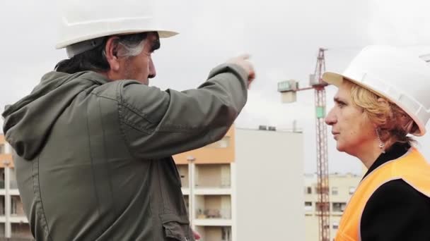 Trabajadores de la construcción discutiendo planes en tableta — Vídeos de Stock