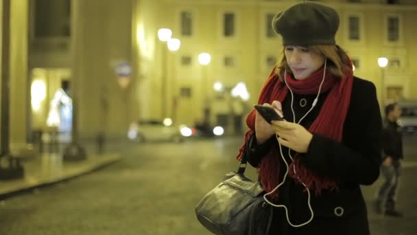 女性がスマート フォンを使用して音楽を聴く — ストック動画