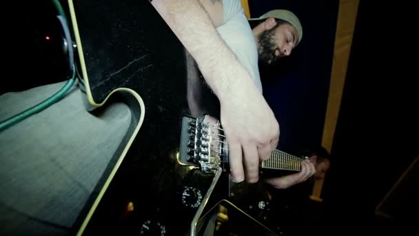 Мужской рок-гитарист играет на электрогитаре в студии — стоковое видео