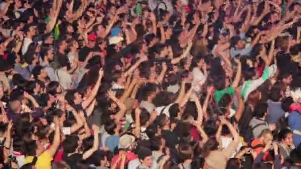 Профиль огромной толпы людей, танцующих и хлопающих в ладоши во время концерта — стоковое видео