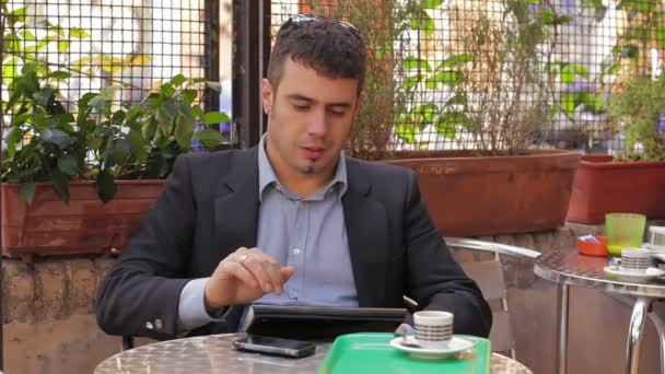 Podnikatel pracuje na tabletovém počítači v kavárně — Stock video