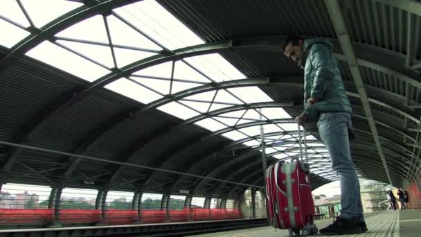Чоловік чекає на потяг, який прийде — стокове відео