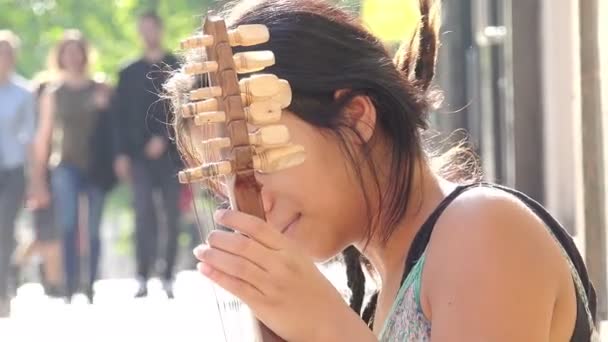 Jonge vrouwelijke straat kunstenaar spelen op de stoep — Stockvideo