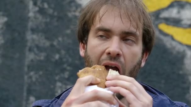 Молодой человек ест кебаб — стоковое видео