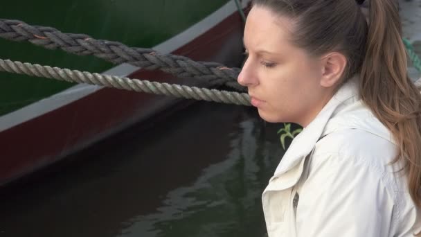 Грустная женщина, сидящая на пристани — стоковое видео