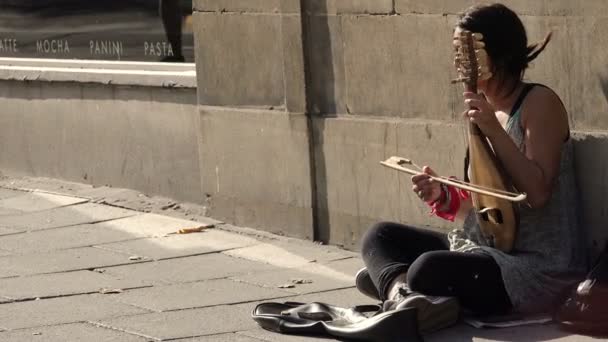Нищая женщина играет музыку и просит милостыню — стоковое видео