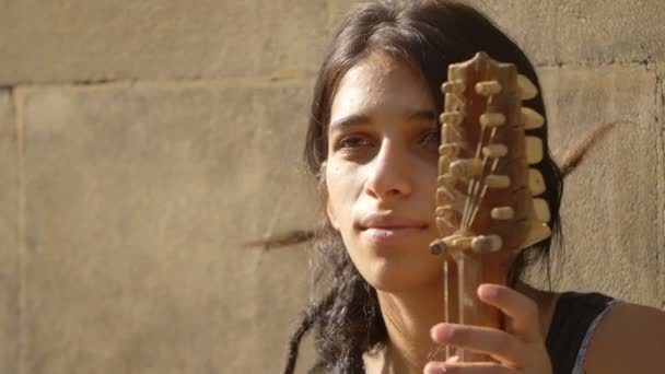 Portret van een jonge Oost-Europese vrouw spelen een tekenreeks in de straat — Stockvideo