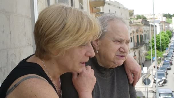 Літня жінка і її старша дочка говорять на балконі будинку — стокове відео