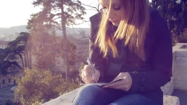 Jeune femme écrivant sur un bloc-notes — Video