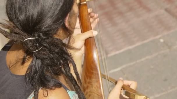 Female busker playing the gusle, old string instrument — Stockvideo